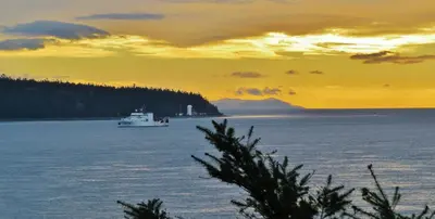 a boat in a large body of water at sunset at Above Tide Motel in Campbell River