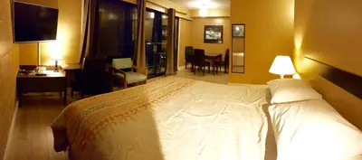 a bedroom with a large white bed and a desk at Above Tide Motel in Campbell River