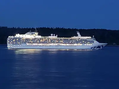 a cruise ship on the water at night at Above Tide Motel in Campbell River