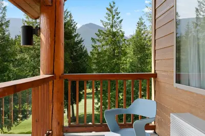 a porch with a chair and a view of the mountains at Kootenay Lakeview Resort BW Signature Collection in Balfour