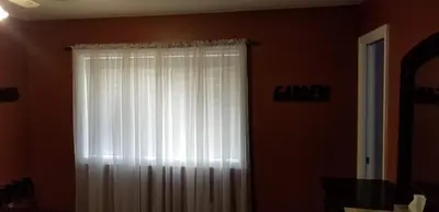 a window with white curtains in a room at Silver Star Bed and Breakfast in Vernon