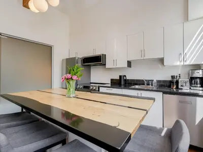 a kitchen with a table with a vase of flowers on it at Old Town Retreat-your artful escape in Victoria’s historic Old Town by Victoria Prime! in Victoria
