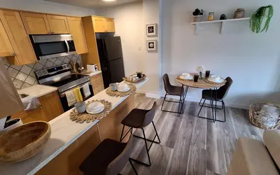 a kitchen with a table and chairs in a kitchen at Modern 1br Apt, Up to 4 people, Steps to 17th Ave, Downtown & Stampede in Calgary