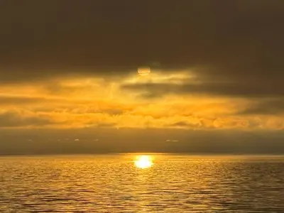 a sunset over the ocean with the sun in the sky at Sea 'N' Stars BNB in Gabriola