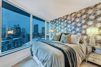 a bedroom with a bed and a large window at Modern 2BR 2BA Condo in Heart of Vancouver in Vancouver
