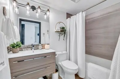 a bathroom with a toilet and a sink and a mirror at Modern 2BR 2BA Condo in Heart of Vancouver in Vancouver