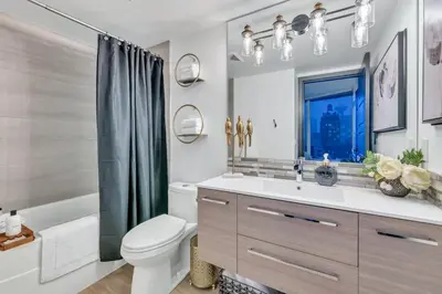 a bathroom with a sink and a toilet and a mirror at Modern 2BR 2BA Condo in Heart of Vancouver in Vancouver