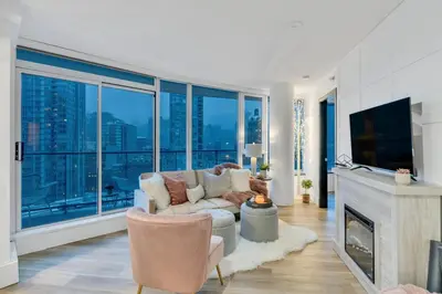 a living room with a couch and a large window at Modern 2BR 2BA Condo in Heart of Vancouver in Vancouver