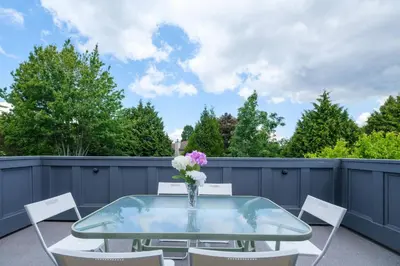 a glass table with white chairs and a vase of flowers at Surrey Family Home w/ Patio & Garden – 3BR 2BA in Surrey