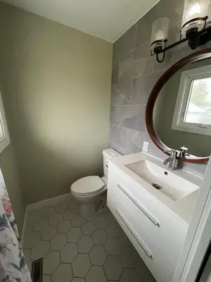 a bathroom with a toilet and a sink and a mirror at Cozy Riverdale Home in Whitehorse