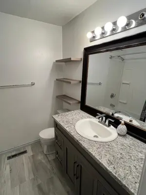 a bathroom with a sink and a mirror and a toilet at Cozy Riverdale Home in Whitehorse