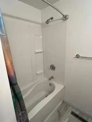 a white bathroom with a tub and a shower at Cozy Riverdale Home in Whitehorse