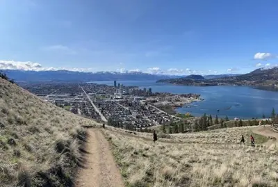 a dirt road on top of a hill with a body of water at Knox Mountain Vista 2 Bdrm Suite in Kelowna