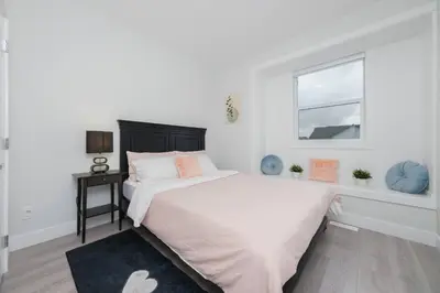 a white bedroom with a large bed and a window at Modern 3BR Near Langley Events Centre & EV charger in Langley