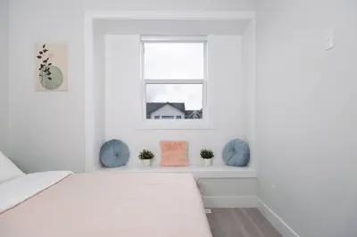 a white bedroom with a bed and a window at Modern 3BR Near Langley Events Centre & EV charger in Langley