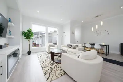 a white living room with a white couch and a table at Modern 3BR Near Langley Events Centre & EV charger in Langley