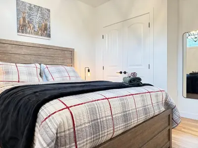 a bedroom with a large bed with a wooden headboard at Rustic Rocky Retreat in Calgary