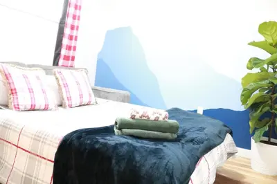 a bed with a blue blanket and a stuffed animal on top at Rustic Rocky Retreat in Calgary