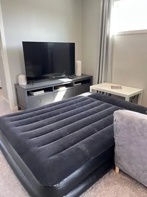 a bedroom with a large bed and a flat screen tv at Le Reve Show Home 3BD, AC, sleep 9 , Beaumont in Nisku
