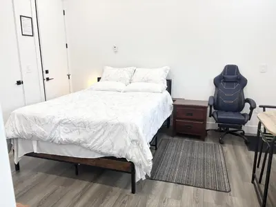 a bedroom with a bed and a desk and a chair at Bird Nest Suites in Surrey