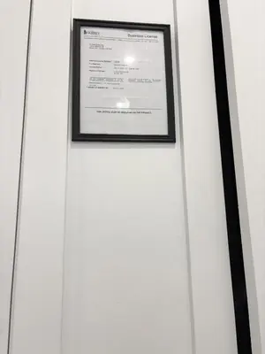 a framed picture of a document on a white wall at Bird Nest Suites in Surrey