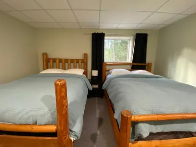 two twin beds in a room with a window at Blind Bay Chalet 2 Bedroom Private Suite in Blind Bay
