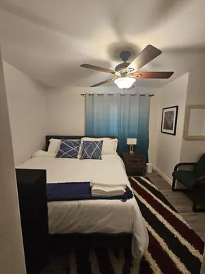 a bedroom with a bed with a ceiling fan at Aansel Suites 2 bedroom in Edmonton