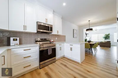 a kitchen with white cabinets and a stove top oven at FreshModernWEMGarageKingBed in Edmonton