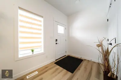 an empty living room with a window and a black rug at FreshModernWEMGarageKingBed in Edmonton