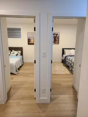 a room with two beds and a hallway with two mirrors at Spacious 2 Bedroom Suite in Gorman, Edmonton, Canada in Edmonton