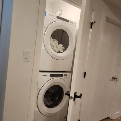a washer and dryer in a room with a door at Spacious 2 Bedroom Suite in Gorman, Edmonton, Canada in Edmonton