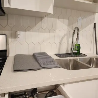 a kitchen counter with a sink and a cutting board at Spacious 2 Bedroom Suite in Gorman, Edmonton, Canada in Edmonton