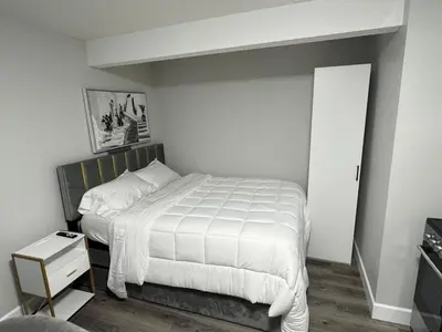 a bedroom with a large bed with a white comforter at True Haven in Prince George