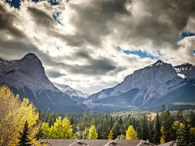 a view of a mountain range under a cloudy sky at Ha Ling Haven - Penthouse with Shared Rooftop Hot Tub in Canmore