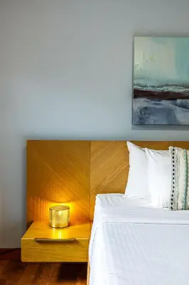 a bedroom with a white bed with a wooden headboard at Ha Ling Haven - Penthouse with Shared Rooftop Hot Tub in Canmore