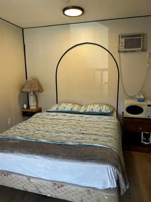 a bedroom with a large bed with a large headboard at Lakecity Inn in Penticton
