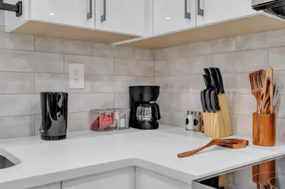 a kitchen counter top with a coffee maker and utensils at Cozy Luxe Suite in Calgary
