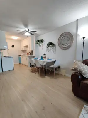a living room with a table and chairs and a kitchen at Stay Heart of Calgary, Enjoy Night Life, Free Parking Incl in Calgary