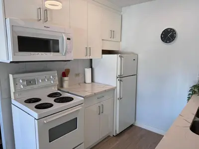 a kitchen with a white stove and a refrigerator at Stay Heart of Calgary, Enjoy Night Life, Free Parking Incl in Calgary