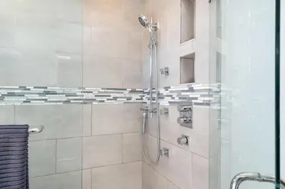 a bathroom with a shower with a glass door at Family-Friendly 3BR Home in Vancouver