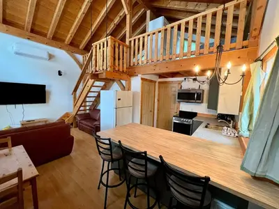 a kitchen and living room with a bar in a cabin at Alpenrose 4, Hottub, Mountains View, AC, sleep 5 in Golden