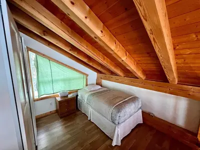 a bedroom with a bed in a wooden attic at Alpenrose 4, Hottub, Mountains View, AC, sleep 5 in Golden