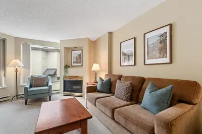 a living room with a couch and a chair at 1BR and Sofabed in Marquise, Close to Ski Hill, Fireplace, Hot Tub and Sauna, Gym in Whistler