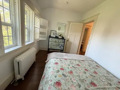 a bedroom with a bed and a radiator and windows at Spacious Villa 6BR 3 BA - Free Parking - Near Kitsilano Beach & Attractions - 15' to DT in Vancouver
