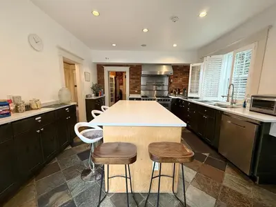 a kitchen with a island with stools in it at Spacious Villa 6BR 3 BA - Free Parking - Near Kitsilano Beach & Attractions - 15' to DT in Vancouver