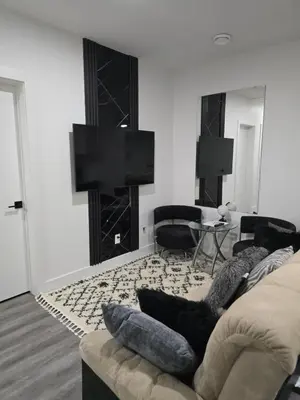 a living room with a couch and a tv at 2 bedroom cozy suite in NW edmonton with separate entrance, FreeWifi, driveway Parking, Netflix, AC, airport pickup in Edmonton