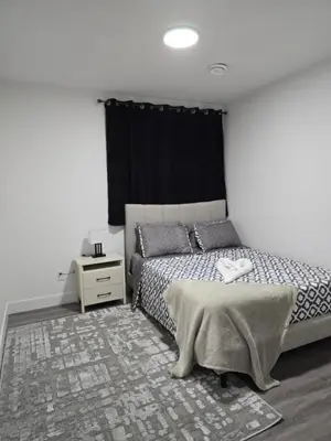 a bedroom with a bed and a table with a cross on it at 2 bedroom cozy suite in NW edmonton with separate entrance, FreeWifi, driveway Parking, Netflix, AC, airport pickup in Edmonton