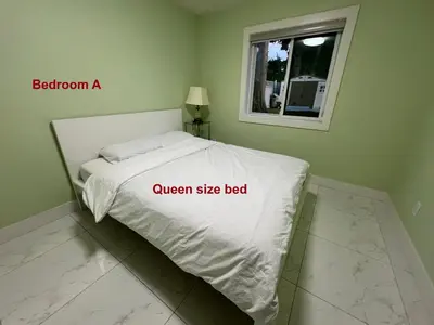 a bed in a bedroom with a sign that reads queen size bed at Newton Suite in Surrey