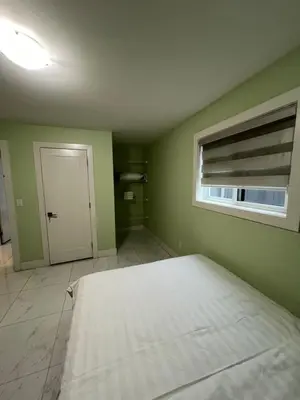a bedroom with a white bed and a window at Newton Suite in Surrey
