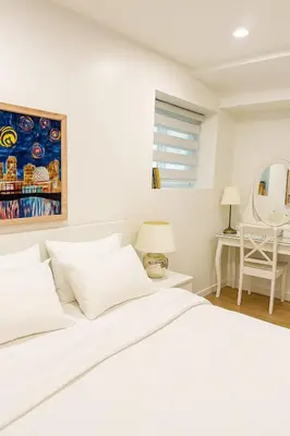 a white bedroom with a bed and a table at Deep Cove holiday in North Vancouver